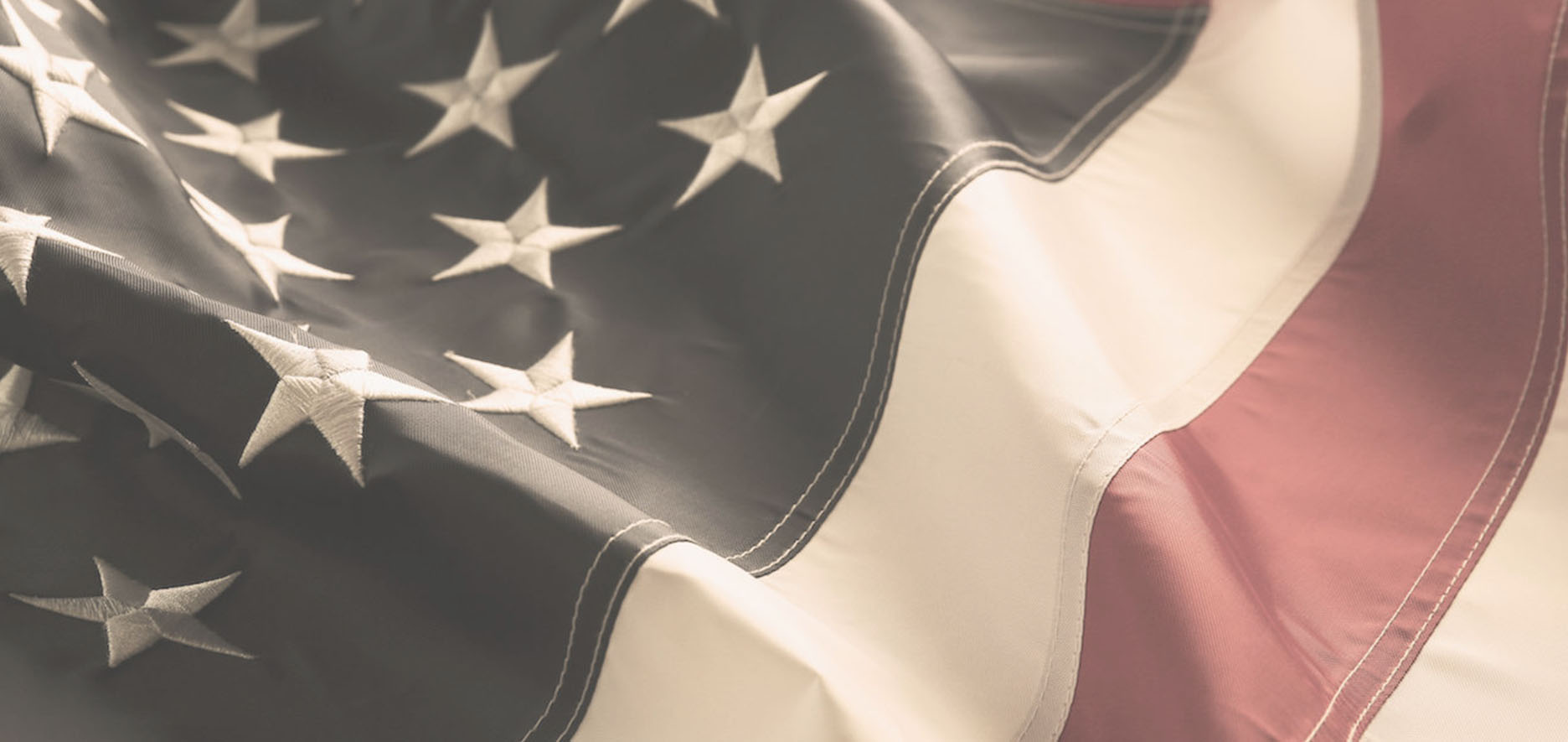 Close-Up Of A Slightly Wrinkled American Flag, Focusing On The Stars And Stripes.